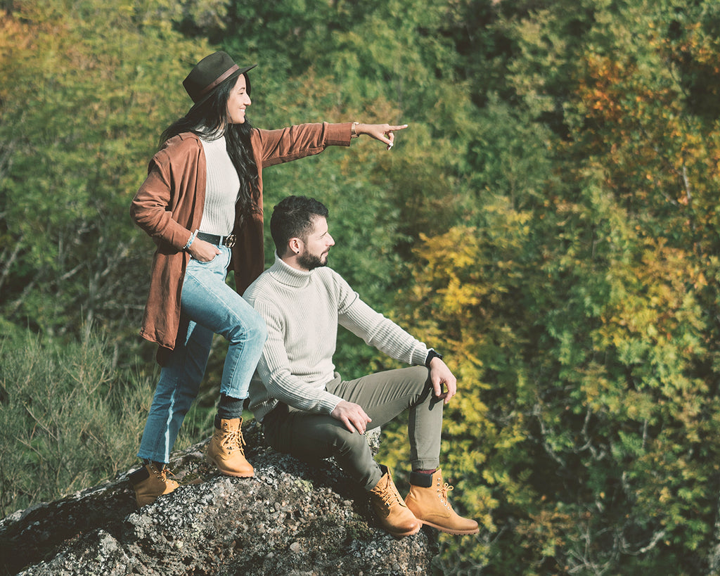 Chico y chica mirando a lo lejos con un bosque en el fondo